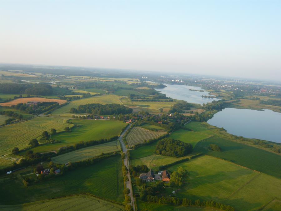 Im Bild: Blick aus der Höhe aus Richtung Postfeld in Richtung Pohnsdorf. Rechts ist der Postsee zu sehen, in der Bildmitte der Ortsteil Sieversdorf; Quelle: Dirk Maaß